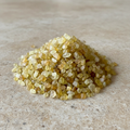 Yellow Sapphire Crystal Chips arranged on a warm neutral stone surface