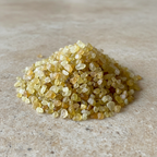 Yellow Sapphire Crystal Chips arranged on a warm neutral stone surface