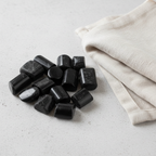 Black Tourmaline tumble stones arranged with neutral linen décor